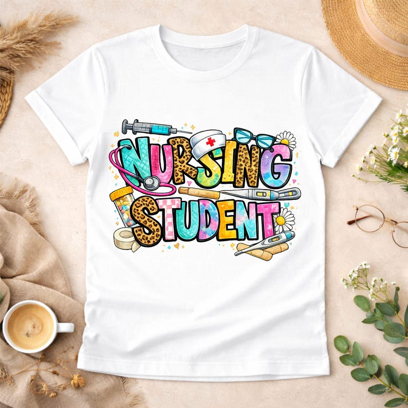 May include: White t-shirt featuring a vibrant "NURSING STUDENT" design. The graphic incorporates medical instruments such as a stethoscope, syringe, and thermometer. The text uses leopard print, tie-dye, and solid colours, with daisy details.