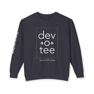 May include: A dark blue sweatshirt with white text that reads "dev o tee" in a box with a fleur-de-lis above and below the "o". Below the box, it reads "Sacred Paths Home". The left sleeve has white text that reads "I'm on my way home."