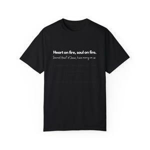May include: Black t-shirt with white text that reads "Heart on fire, soul on fire. Sacred Heart of Jesus, have mercy on us."
