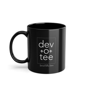 Op de afbeelding: Zwarte keramische koffiemok met witte tekst die "dev o tee" en "Sacred Paths Home" zegt.