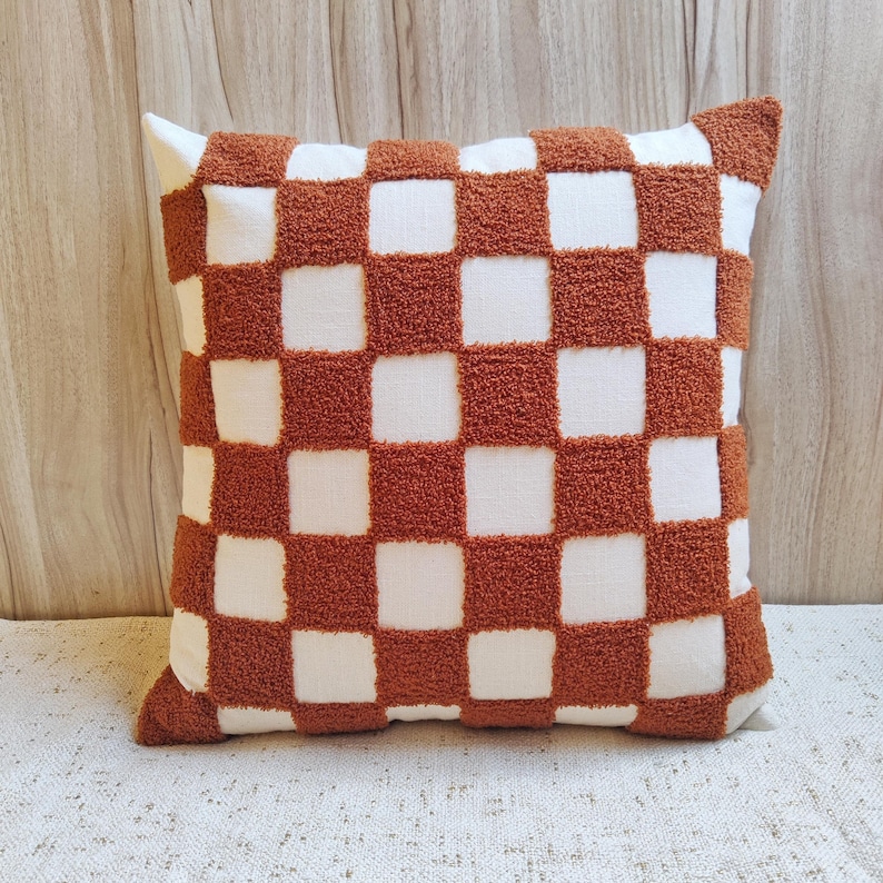 May include: A brown and white checkered throw pillow with a soft, fuzzy texture.