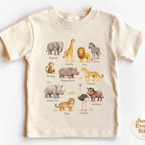 Op de afbeelding: Crèmekleurig T-shirt voor kinderen met aquarel illustraties van verschillende safaridieren, waaronder een olifant, giraffe, leeuw en zebra. Elk dier is voorzien van zijn naam. Het shirt is ontworpen voor kinderen.
