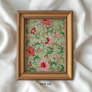 May include: A framed print featuring a floral pattern with red and pink flowers, green leaves, and swirling vines on a light green background. The frame is a warm, golden brown color. The text "WALL ART FINDS" is at the bottom.