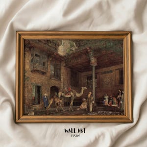 May include: A framed print of an orientalist painting depicting a courtyard scene with camels, figures in traditional attire, and architectural details. The artwork is in a wooden frame, with the text "WALL ART FINDS" at the bottom.