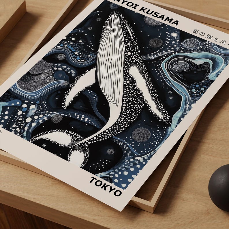 K&ouml;nnte beinhalten: Ein abstrakter Druck in Schwarz und Blau mit einem wei&szlig;en Wal mit schwarzen Punkten. Der Druck enth&auml;lt den Text "Yayoi Kusama" und "Tokyo" in schwarzer Schrift. Der Text "星の海の波" ist ebenfalls in schwarzer Schrift enthalten.
