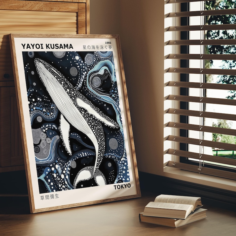 K&ouml;nnte beinhalten: Ein gerahmter Druck eines schwarz-wei&szlig;en Wals, der in einem blauen und wei&szlig;en abstrakten Muster schwimmt. Der Druck ist betitelt mit "Yayoi Kusama, Stern des Meeres, 1965, Tokio, Fr&uuml;he Werke".