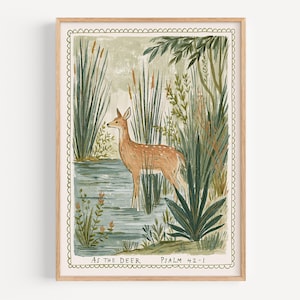 May include: A framed art print featuring a deer standing in a pond surrounded by tall reeds and lush greenery. The artwork has a soft color palette of greens, browns, and blues. Text at the bottom reads "As the Deer" and "Psalm 42-1".