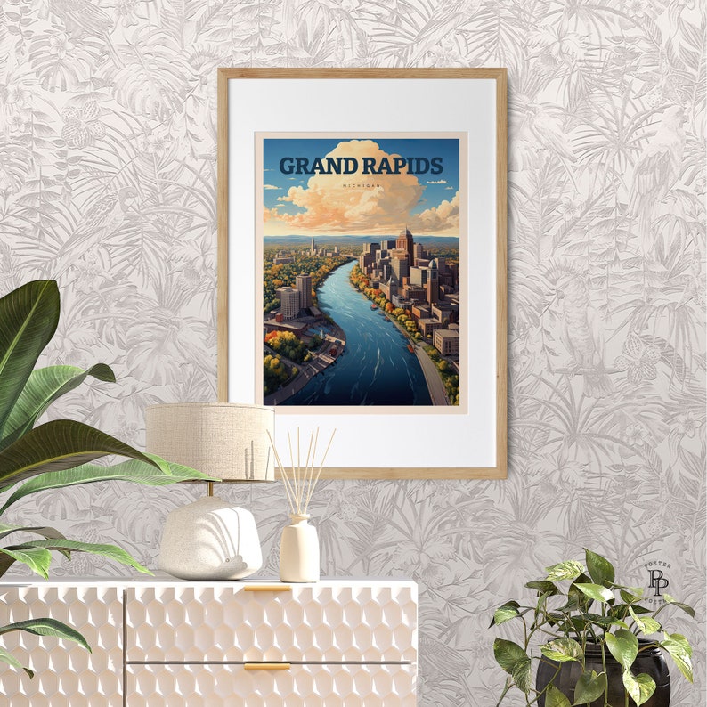 May include: A vintage-style travel poster featuring an aerial view of Grand Rapids, Michigan. The poster is framed in a light wood frame and is displayed on a white wall with a tropical leaf pattern.