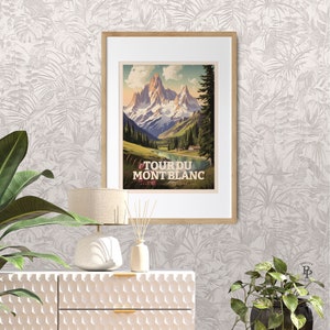 May include: A vintage-style travel poster with a mountain scene. The poster features a mountain range with snow-capped peaks, a lake, and a small village. The text on the poster reads "Tour du Mont Blanc".