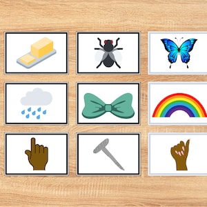 Può includere: Nove carte colorate con varie immagini, tra cui un panetto di burro, una mosca, una farfalla, una nuvola con gocce di pioggia, un papillon, un arcobaleno, una mano che punta, un chiodo e una mano con le unghie curate.