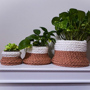 Set of crochet storage baskets with wooden base for home decor.