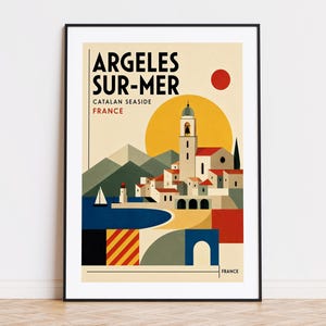 Könnte beinhalten: Ein gerahmtes Reiseplakat mit dem Text ARGELES SUR-MER CATALAN SEASIDE FRANCE. Die grafische Illustration zeigt eine Küstenstadt mit einem Glockenturm, weißen Gebäuden, einem blauen Meer, einem Segelboot und Bergen unter einer großen gelben Sonne.