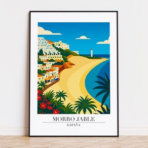 May include: A framed art print featuring a coastal scene of Morro Jable, Spain. The illustration depicts a beach, buildings, a lighthouse, and palm trees under a blue sky. The text "MORRO JABLE ESPAÑA" is at the bottom.