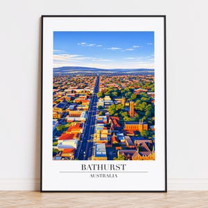 May include: An aerial view art print of Bathurst, Australia, framed in black. The image showcases a long road cutting through a town with red-roofed buildings, green trees, and a blue sky. The text "BATHURST AUSTRALIA" is at the bottom.