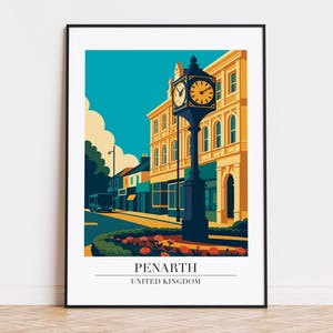 May include: A framed art print featuring a stylized illustration of Penarth, United Kingdom. The artwork depicts a clock tower, buildings, and a bus against a teal sky. The clock face is yellow, and the buildings are a warm yellow color.
