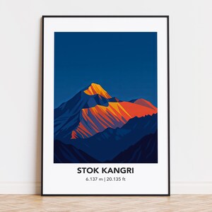 May include: A framed art print featuring a stylized mountain landscape. The artwork depicts a mountain with orange and yellow peaks against a dark blue sky. The text "STOK KANGRI" is below the image, with the elevation listed as 6,137 m | 20,135 ft.