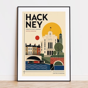 May include: A framed travel poster featuring a stylised illustration of Hackney, London. The print displays the Hackney Town Hall, a canal with a boat, and brick buildings in a palette of cream, yellow, red, and blue. Text reads HACKNEY CREATIVE EAST LONDON UNITED KINGDOM.