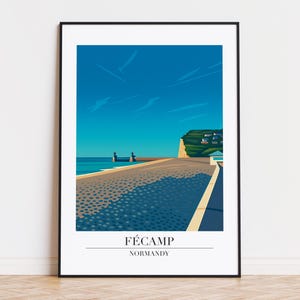 以下が含まれることがあります： フェカン、ノルマンディーの海岸の風景を描いた額入りのアートプリント。明るい青い空の下、海へと続く道が描かれています。プリントの下部には「Fécamp」と「Normandy」の文字が記されています。