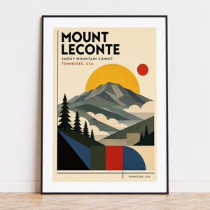 May include: A framed art print depicting Mount LeConte in the Smoky Mountains, Tennessee, USA. The artwork uses a geometric style with a yellow sun, red dot, and blocks of colour. The text "MOUNT LECONTE" is at the top of the print.