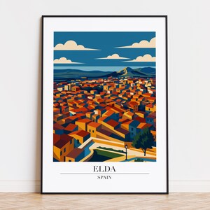 Puede incluir: Una impresión artística enmarcada que presenta una ilustración estilizada de Elda, España. La obra de arte representa un paisaje urbano con tejados de tejas rojas, sobre un cielo azul con nubes. La impresión incluye el texto "ELDA" y "SPAIN".
