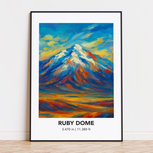 Op de afbeelding: Een ingelijste kunstdruk met een abstract schilderij van Ruby Dome. Het kunstwerk toont een berg met besneeuwde toppen, in blauw, oranje en geel. De tekst "RUBY DOME" en de hoogte, 3.470 m | 11.380 ft, staan onderaan.