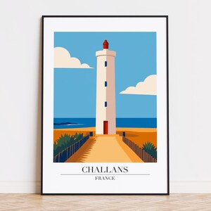 May include: A framed art print featuring a minimalist illustration of a white lighthouse with a red top, set against a blue sky and ocean. The artwork includes the text "CHALLANS FRANCE" at the bottom, with a path leading to the lighthouse.