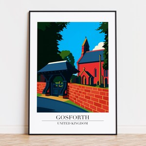 May include: A framed art print featuring a stylized illustration of Gosforth, United Kingdom. The artwork depicts a red church and brick wall, a blue gate, and a blue sky. The text "GOSFORTH UNITED KINGDOM" is at the bottom.