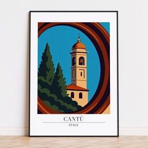 May include: A framed art print featuring a stylized illustration of a church tower in Cantù, Italy. The tower is beige with a red roof and bell openings, set against a blue sky. The artwork is framed with a brown arch and includes the text "CANTÙ ITALY".