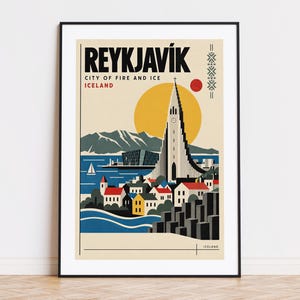 Op de afbeelding: Een ingelijste reisposter van Reykjavík, IJsland, met de Hallgrímskirkja-kerk, een gele zon, bergen en kleurrijke huizen. De tekst luidt REYKJAVÍK, CITY OF FIRE AND ICE, ICELAND. Het ontwerp gebruikt een palet van blauw, rood en geel.