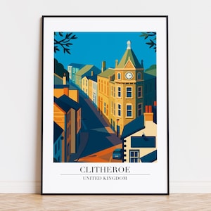 May include: A framed art print featuring a stylized illustration of Clitheroe, United Kingdom. The artwork depicts a street scene with buildings in shades of yellow, orange, and blue under a clear blue sky. The print includes the text "CLITHEROE UNITED KINGDOM".