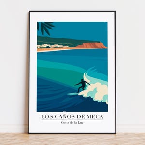 Könnte beinhalten: Gerahmter Kunstdruck mit einem Surfer auf einer Welle. Das Kunstwerk im minimalistischen Stil verwendet Blau- und Grüntöne und zeigt eine Küstenlandschaft. Der Text lautet "LOS CAÑOS DE MECA" und "Costa de la Luz".