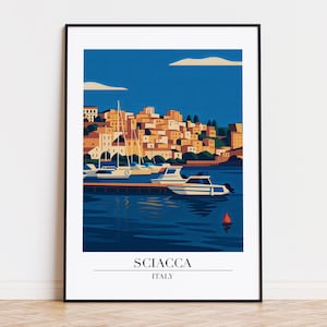 May include: A framed art print of Sciacca, Italy, featuring a harbor scene with boats and buildings. The artwork uses a minimalist style with a blue and orange color palette. The text "SCIACCA ITALY" is displayed at the bottom.
