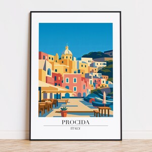 May include: A framed art print featuring a colorful illustration of Procida, Italy. The image depicts buildings in shades of yellow, pink, and blue, with a clear blue sky. The print includes the text "PROCIDA ITALY".