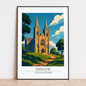Puede incluir: Una impresión artística enmarcada que presenta una ilustración estilizada de la catedral de Armagh, Reino Unido. La obra de arte representa el edificio con dos agujas, sobre un cielo azul con nubes. La impresión incluye el texto "ARMAGH UNITED KINGDOM".