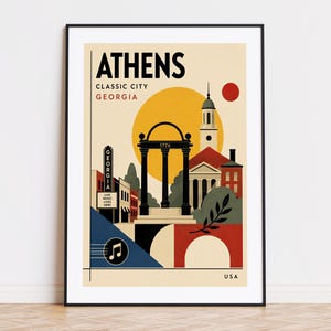 May include: A framed travel poster of Athens, Georgia, featuring the iconic arch with the date 1776, a historic building, a theatre marquee labelled Georgia Live Music Lives Here, a large yellow sun, a musical note icon, and the text USA.