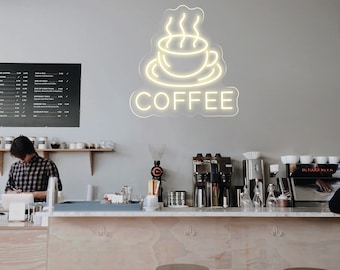 May include: A white neon sign with a coffee cup and steam design. The sign says "COFFEE" in a white neon font.