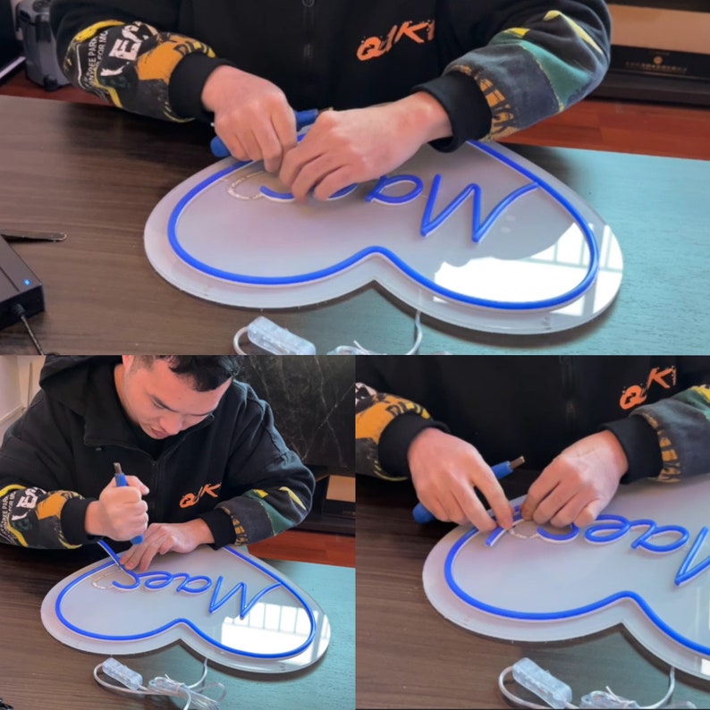Op de afbeelding: Een persoon assembleert een blauw neon-bord in de vorm van een hart met het woord "Made" erin. Het bord staat op een wit oppervlak.