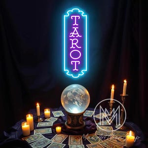May include: A neon sign reading "TAROT" in purple, edged with blue, is positioned above a crystal ball. Lit candles and tarot cards are laid out on a dark blue cloth, creating a mystical atmosphere.