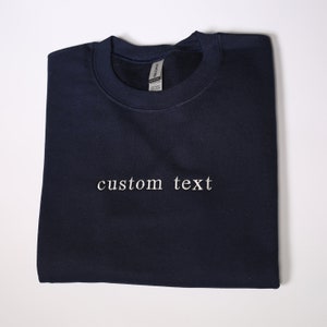 Może przedstawiać: Szarfa w kolorze granatowym z haftem "custom text" w kolorze białym z przodu.