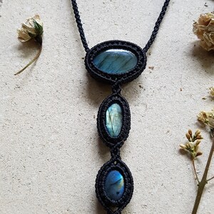 Puede incluir: Un collar de cord&oacute;n negro con tres piedras ovaladas de labradorita. Las piedras son de un azul profundo con destellos iridiscentes de verde y oro.