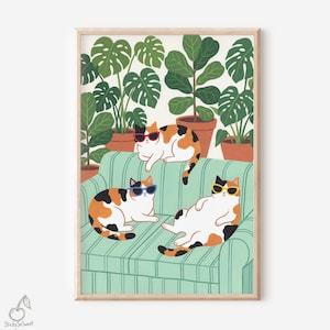 Può includere: Una stampa artistica incorniciata con tre gatti calico con occhiali da sole, sdraiati su un divano a righe verdi. Le piante in vaso sono sullo sfondo. La stampa ha una cornice in legno chiaro e il logo "StickySoSweet" nell'angolo in basso a sinistra.