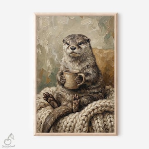 May include: A framed print of an otter holding a mug of coffee, sitting on a cream-colored knitted blanket. The otter has brown fur and is looking directly at the viewer. The background has a neutral color palette.