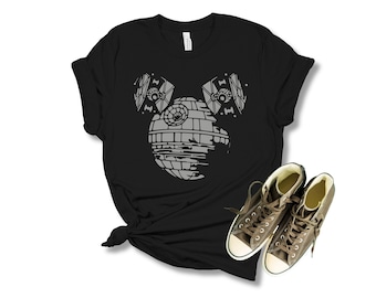 May include: Black t-shirt with a gray graphic of the Death Star from Star Wars, with two TIE fighters on either side of it. The Death Star is shaped like Mickey Mouse's head.