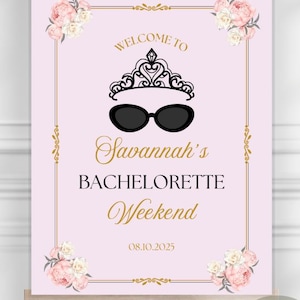 以下が含まれることがあります： イーゼルに立てられたピンク色の看板。金と黒で「Welcome to Savannah's Bachelorette Weekend」と書かれています。ティアラとサングラスのグラフィック、花のアクセント、日付08.10.2025が特徴です。Canvaで完全にカスタマイズ可能。