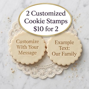 May include: Two round, scalloped-edge cookie stamps with embossed text. One stamp features the text 'Customize With Your Message' and the other features 'Example Text: Our Family'. The stamps are light beige and have a circular design.