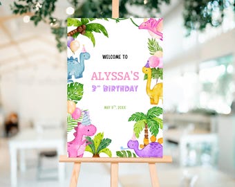 May include: A watercolor-style birthday sign on an easel. The sign reads "Welcome to Alyssa's 3rd Birthday" with dinosaur illustrations and tropical foliage. The color palette includes pink, blue, yellow, and green.