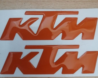 Pair of 3D resin stickers with KTM lettering.