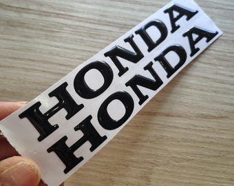 Pair of 3D resin Honda logo stickers.