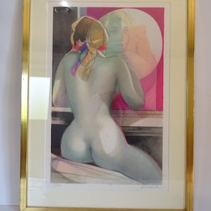 Può includere: Una stampa incorniciata di una donna nuda che si guarda allo specchio. La donna ha i capelli lunghi e biondi e indossa una sciarpa colorata. La stampa è firmata e numerata 9/100.