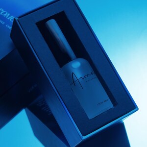 Puede incluir: Imagen azulada de un frasco de perfume en una caja azul oscuro. El frasco esmerilado tiene la palabra "Aroma" en cursiva. La caja est&aacute; en &aacute;ngulo, mostrando el frasco y su sombra. El texto "1 FL OZ 30ml" es visible.